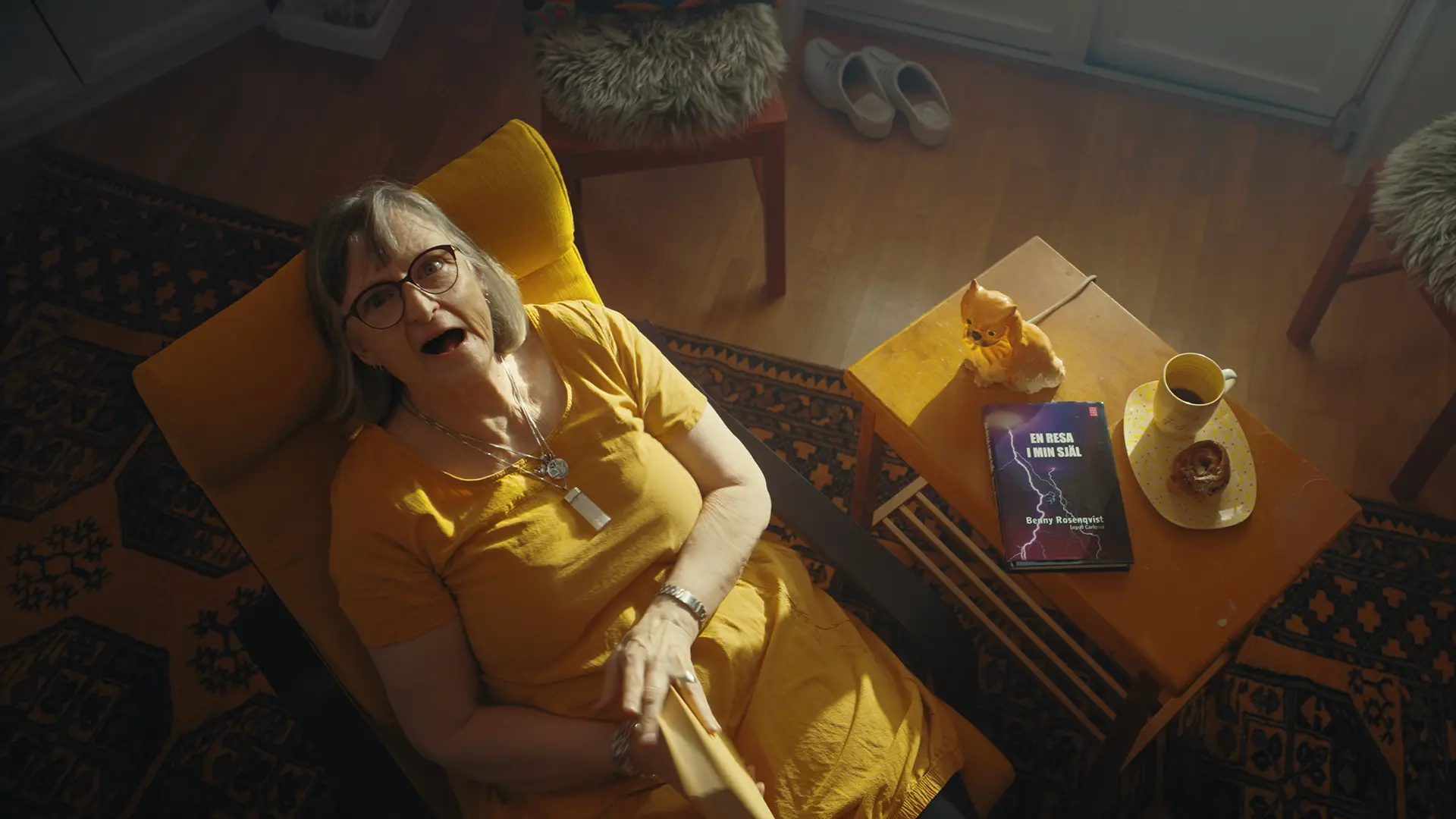 Scen ur Backahills film: en hyresgäst i en gul fåtölj, sedd ovanifrån