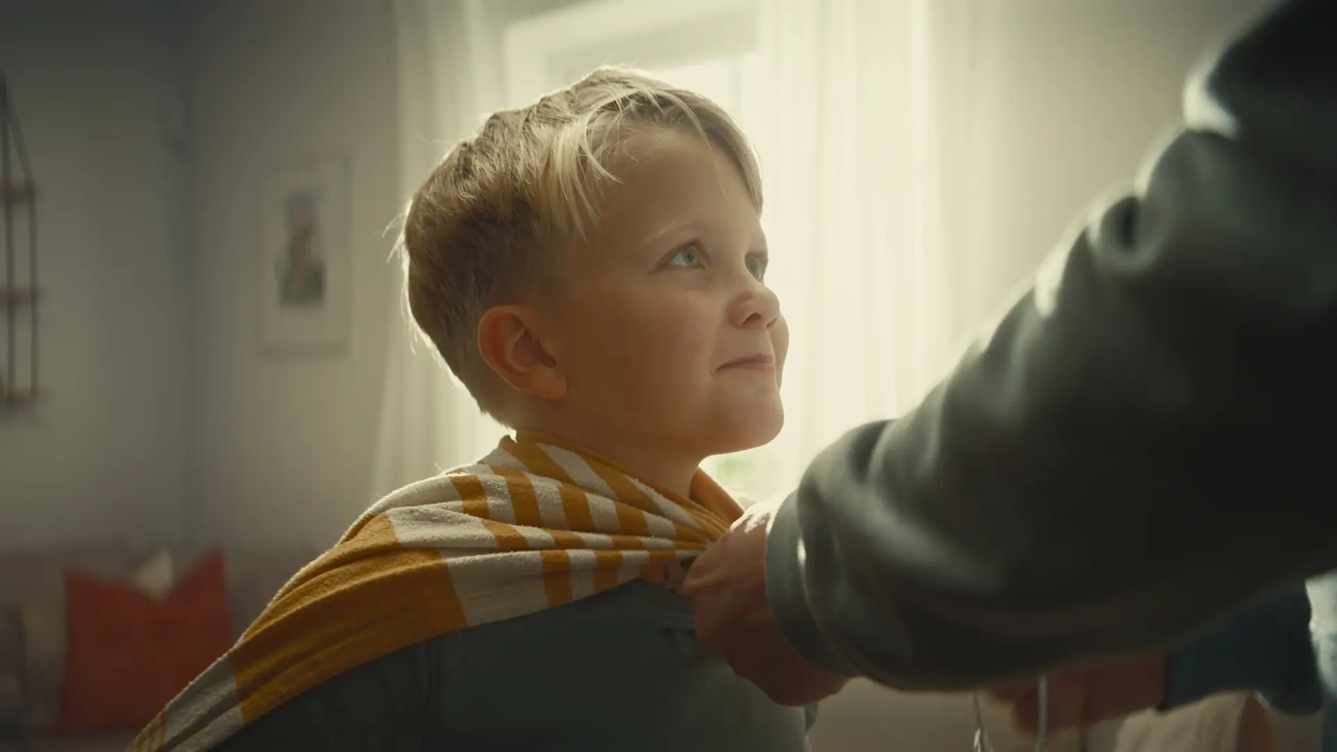 Scen ur Backahills film: ett barn får en handduk om axlarna